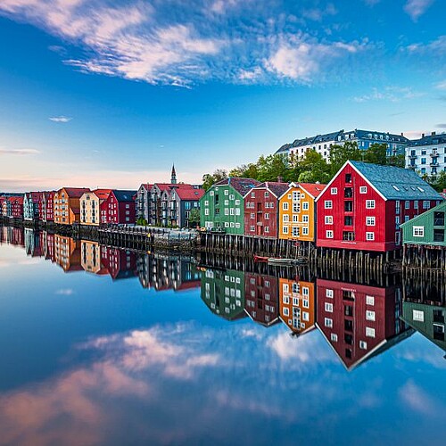 Bunte Häuser spiegeln sich im Wasser im Trondheim Norwegen.