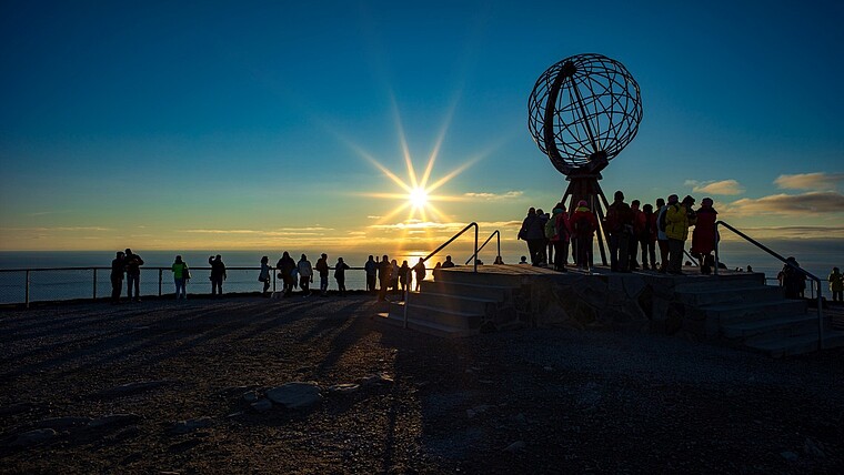 Menschen beobachten den Sonnenuntergang am Nordkap