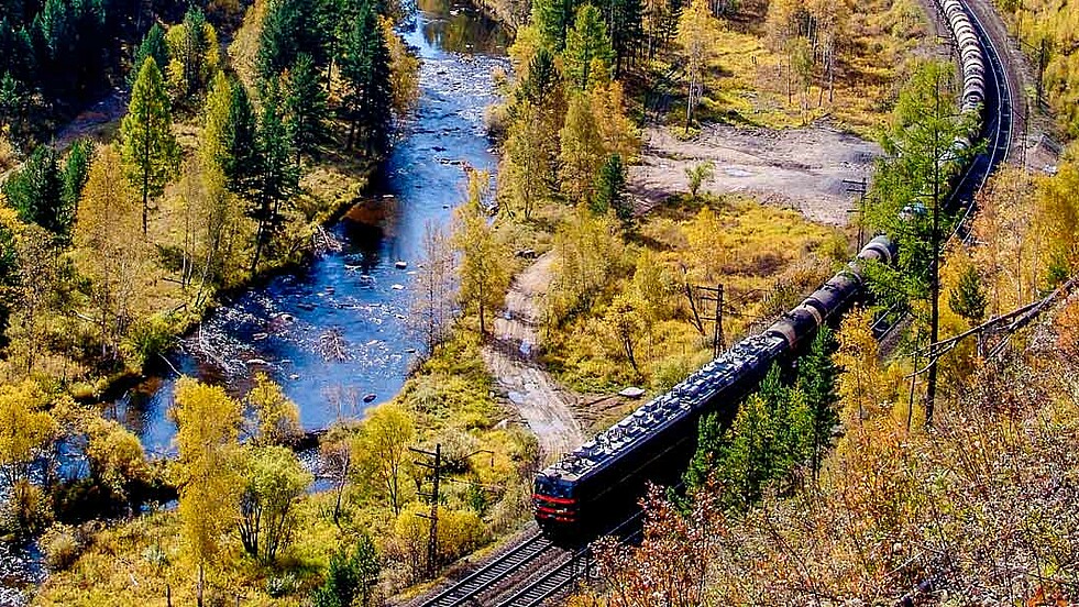 Eisenbahn Zug im Wald neben Fluss auf der Reise Transsib zum Baikal in Russland.