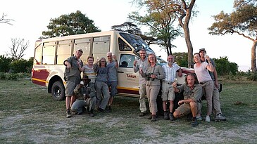 Reisegruppe vor dem TARUK Safari Tourer Geländewagen in Botswana