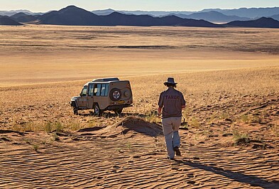 Frau bei Geländewagen in der Namib Wüste
