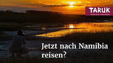 Tourist fotografiert den Sonnenuntergang auf einer Safari im Khaudum Nationalpark in Namibia