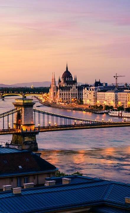 Blick auf eine Brücke vor Budapest im Abendlicht in Ungarn