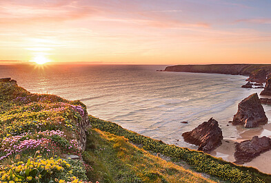 Blick auf eine Steilküste mit Wellen in Cornwall in England