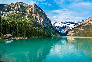 Bergsee mit Fichten vor den Berggipfeln der Rocky Mountains in Alberta, Kanada