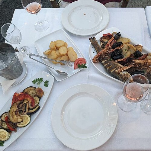 Kroatisches Essen mit Grillgemüse, Kartoffeln und frischem Fisch