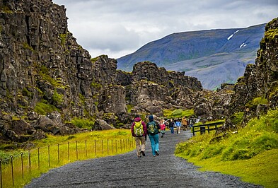 Personen laufen in die Schlucht des Thingvellir Nationalparks