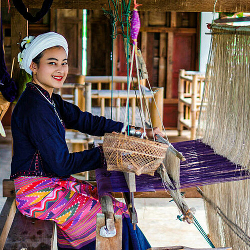 Frau webt an einem Webstuhl in Thailand