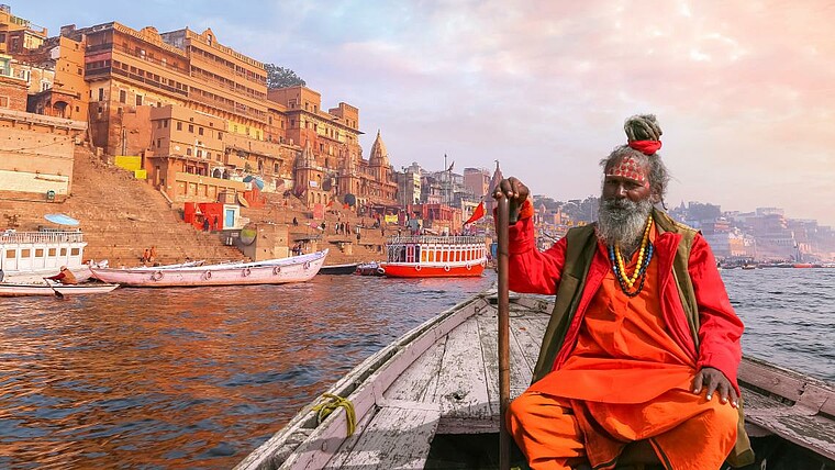 Mann in traditioneller Kleidung im Boot in Indien
