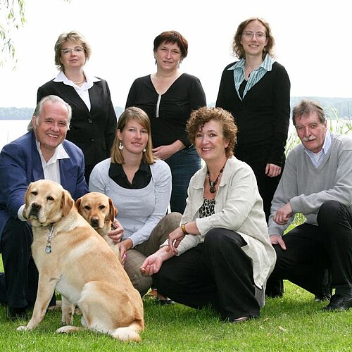 Teamfoto mit Hunden vor See