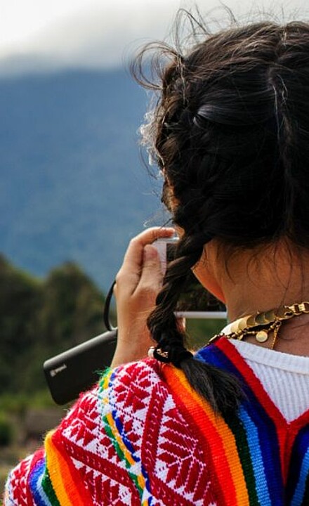 Inka Mädchen in traditioneller Kleidung am Machu Picchu in Peru