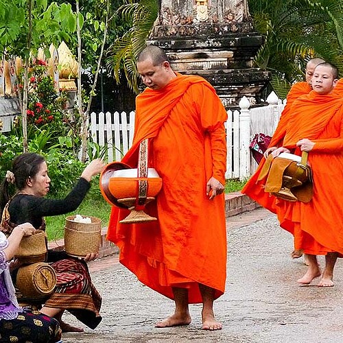 Buddhistische Mönche sammeln in Laos Almosen