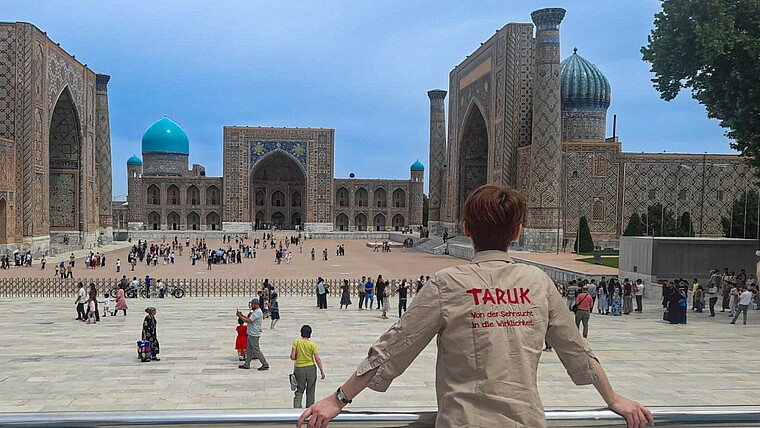 Frau steht am Platz bei Samarkand und schaut sich die Tempel an in Usbekistan