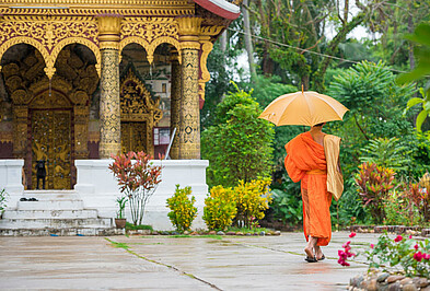 Moench vor einem Tempel in Luang Prabang in Laos