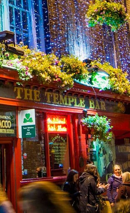 Menschengruppen in Abendstimmung vor dem Temple Pub in Dublin in Irland