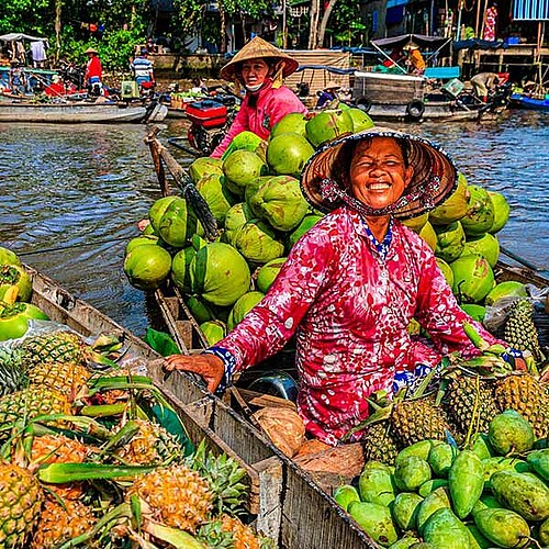 Lachende Frau auf beladenem Boot am Schwimmenden Markt Cai Rang in Can Tho in Vietnam