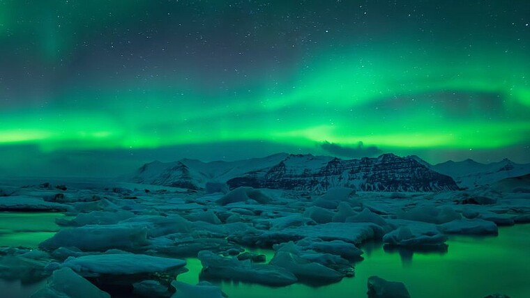 Polarlichter über einem Gletschersee mit Eisschollen auf Island