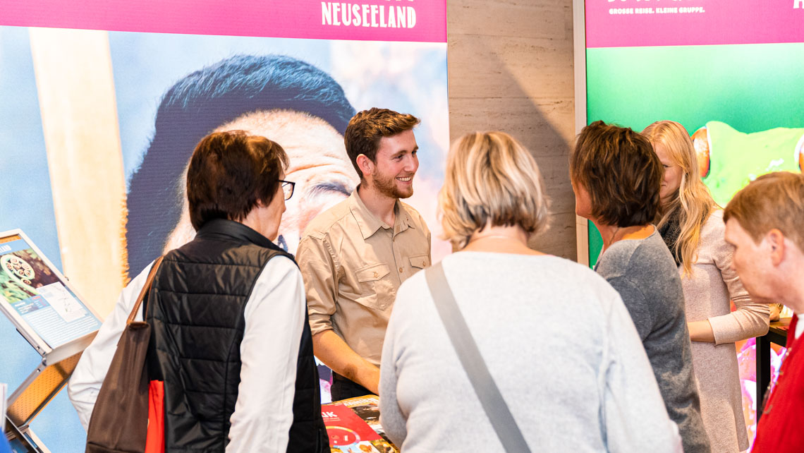 Mann berät Kunden bei einer Reise - Messe