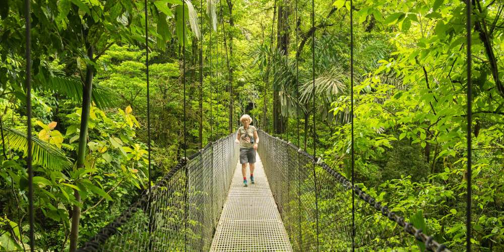 Wandernde Frau auf Hängebrücke im Dschungel bei La Fortuna in Costa Rica
