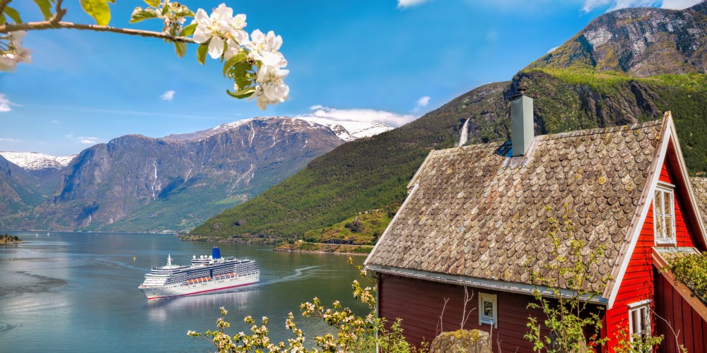Rotes Haus am und Kreuzfahrtschiff auf dem Geiranger Fjord Norwegen