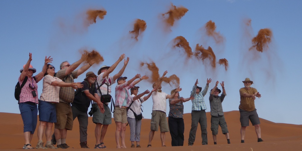 TARUK-Gruppe wirft Sand auf Düne bei Sossusvlei in der Namib-Wüste