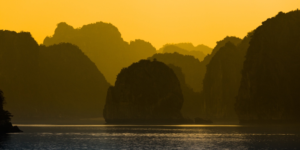 Felsen der Halong Bucht im Nebel bei Sonnenaufgang