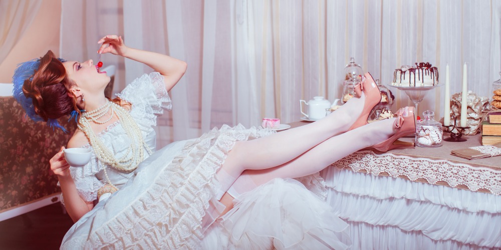 Frau isst im Marie Antoinette Stil eine Kirsche