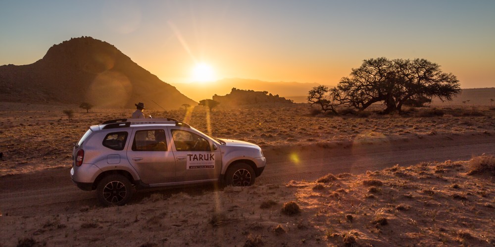 Sonnenuntergang in Namibia mit einem TARUK-Selbstfahrer-Fahrzeug