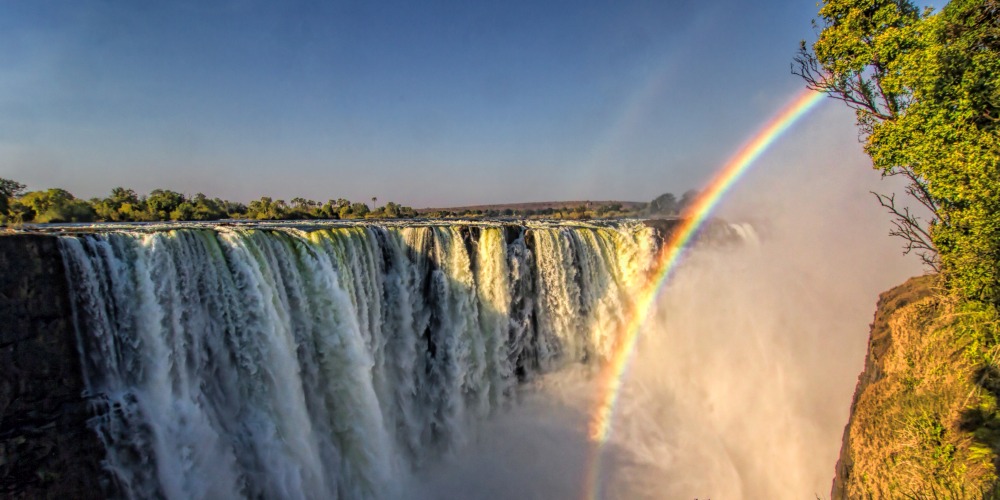 Wasserfall Victoria Falls mit Regenbogen in Simbabwe