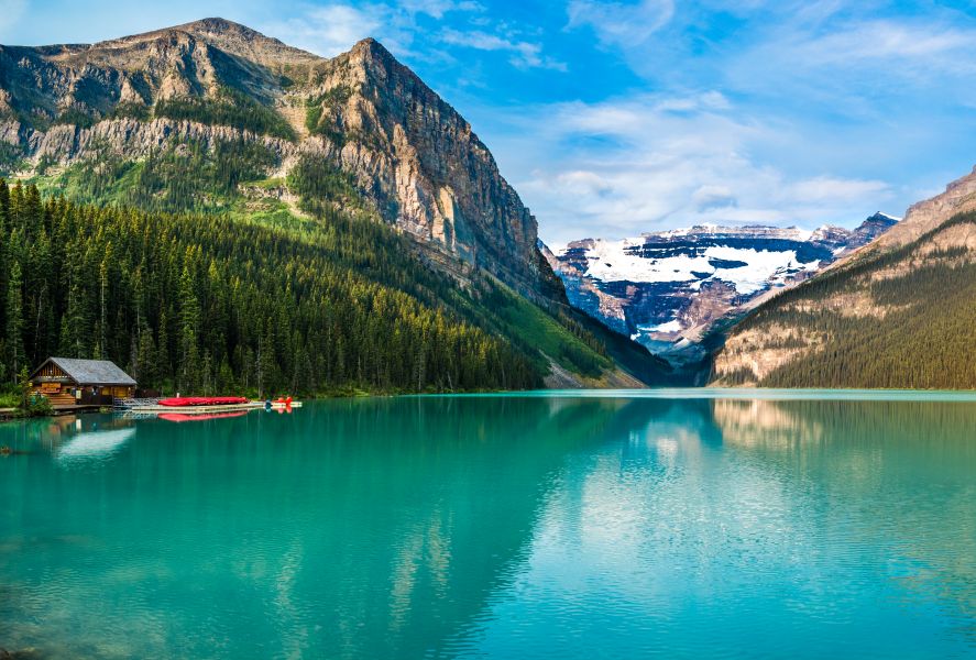 Bergsee mit Fichten vor den Berggipfeln der Rocky Mountains in Alberta, Kanada