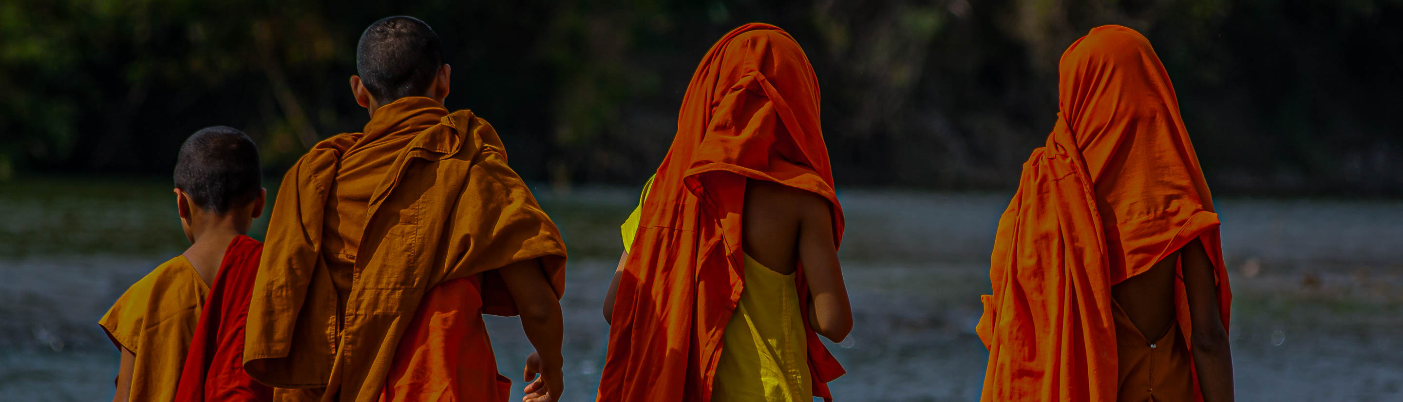 Novizen der Mönche in Laos mit gelb-orangem Gewand.