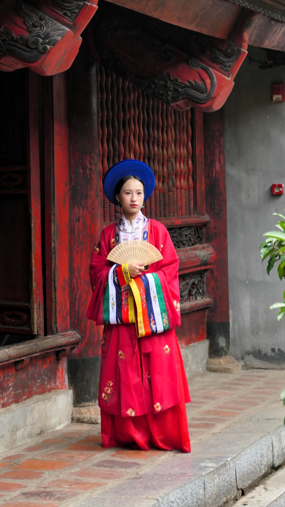 Traditionell gekleidete Frau vor dem Literaturtempel in Hanoi auf der TARUK Reise Lotosblüte