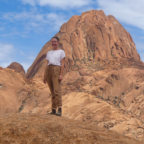 TARUK Mitarbeiterin steht vor der Spitzkoppe in Namibia