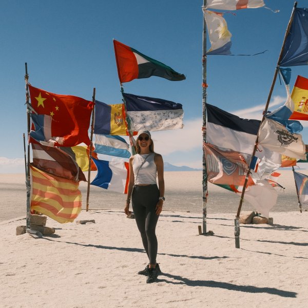 TARUK Mitarbeiterin Luisa Schmidt zwischen bunten Flaggen in Bolivien